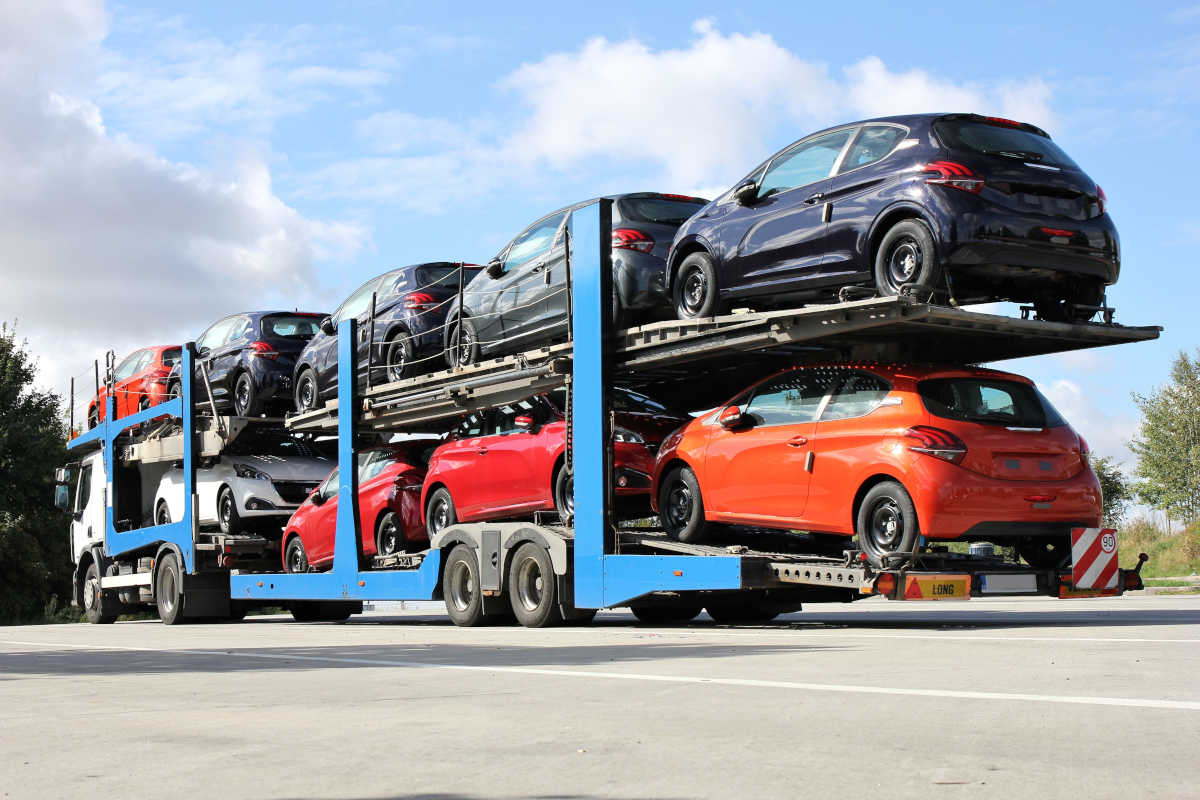 Car transporter truck carrying multiple cars on two levels parked on a road